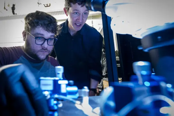 Physicist Ethan Minot and graduate student Brett Clark operate a machine in quantum physics lab