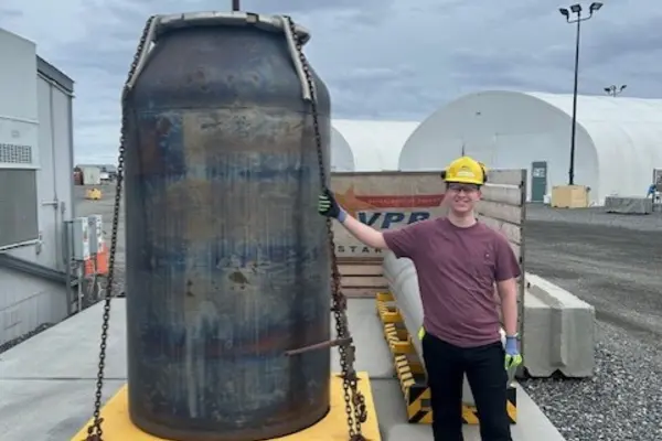 Michael Acosta stands next to a giant barrel at the Hanford Vit Plant